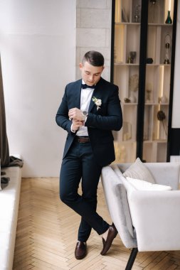 Koyu mavi takım elbiseli yakışıklı damat düğün gününe hazırlanıyor. Stüdyoda damatlar sabahı. Yüksek kalite fotoğraf