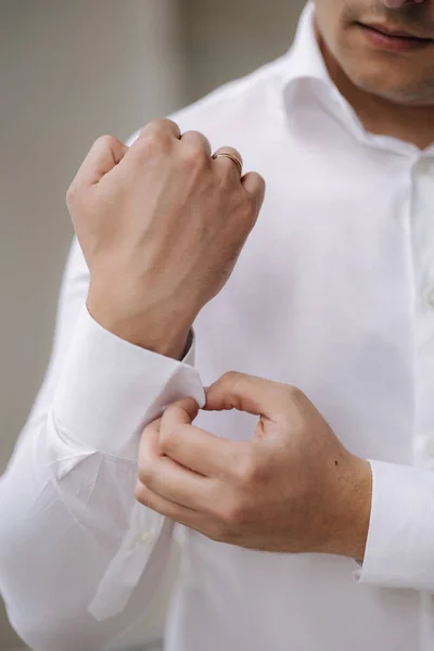 男人的照片把袖扣系在衬衫袖子上 新郎早上在婚礼上高质量的照片 — 图库照片