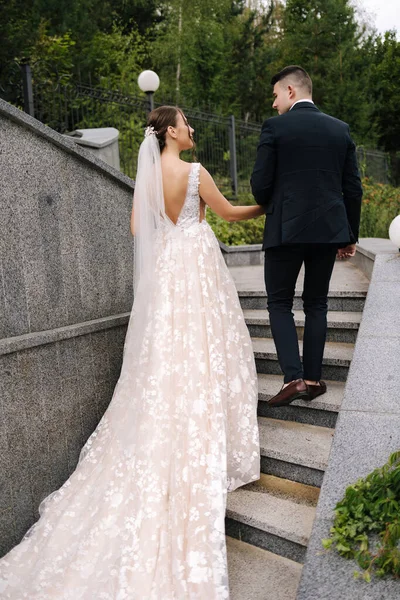 幸福的新婚夫妇一起在大公园里散步 漂亮的新郎在他们的婚礼上是优雅的新娘 高质量的照片 — 图库照片