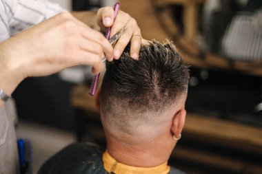 Berber makas kullanıyor ve saç stili yapıyor. Modern berber dükkanı. Yüksek kalite fotoğraf