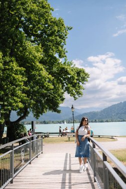 Kot etekli zarif bir kadın küçük köprüde yürüyor ve gülümsüyor. Şık bir kadın. Yüksek kalite fotoğraf