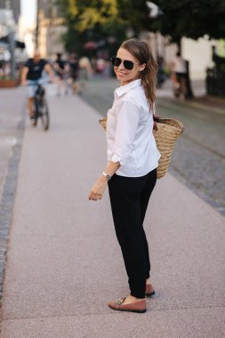 Bir kadının arka görüntüsü şehirde yürür ve kameraya döner. Yüksek kalite fotoğraf