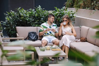 Güzel bir çift terastaki kafede iyi vakit geçirir. Yakışıklı bir erkekle çekici genç bir bayan kafede konuşuyor. Yüksek kalite fotoğraf