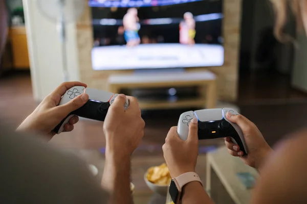 First person view of couple using joysticks to play video games on console . High quality photo