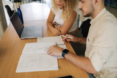 Dizüstü bilgisayar kullanan bir kadın ve sınava hazırlanan bir çocuk. Kütüphanede oturan bir kadın. Sınav konsepti. Yüksek kalite fotoğraf