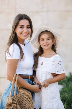 Duvarın önünde anne ve kızının portresi. Şık kızlar. Mutlu aile kavramı. Yüksek kalite fotoğraf