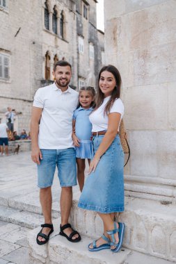 Baba, anne ve beş yaşındaki kızın mutlu ve şık bir aile portresi. Yüksek kalite fotoğraf