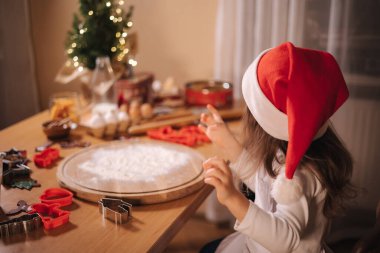 Evde zencefilli ekmek yapıyorum. Annesiyle küçük bir kız zencefilli kurabiye hamuru kesiyor. Noel ve Yeni Yıl gelenekleri. Noel pastanesi. Mutlu tatiller..