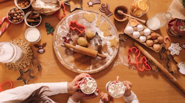 Kış içkisinin en üst görüntüsü, beyaz kazaklı kadın ellerinde lokum olan beyaz kupa. Farklı düz yataklı bir masa. Yeni yıl, geleneksel Noel yemekleri. Şenlikli dekor, kutlama Xmas