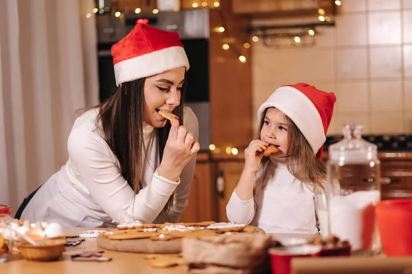 Adorable Petite Fille Mère Chapeau Père Noël Mangeant Pain Épice Photos De Stock Libres De Droits