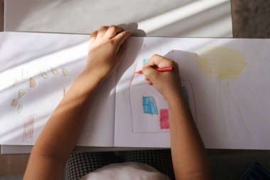 Albümde bir şeyler çizen küçük kızın en iyi görüntüsü. Tatillerde ev aktivitesi. Yüksek kalite fotoğraf