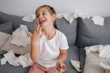 Sevimli ve güzel küçük kız çikolata yiyor ama ellerinde eriyor, o yüzden kız parmaklarını yalıyor. Yüksek kalite fotoğraf