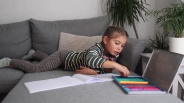 Oturma odasında resim çizen sevimli küçük kız. Kız renkli kalemler kullanmış. Mutlu çocuk. Yüksek kalite fotoğraf