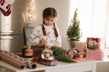 Sevimli beş yaşındaki kız evde Noel çelengi yapıyor. Kış tatiline hazırlanan sevimli küçük kız. Yüksek kalite fotoğraf
