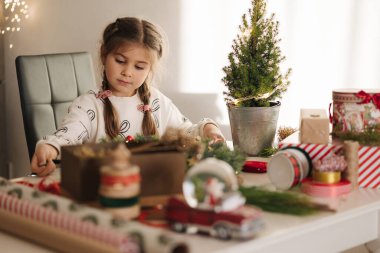 Sevimli beş yaşındaki kız evde Noel çelengi yapıyor. Kış tatiline hazırlanan sevimli küçük kız. Yüksek kalite fotoğraf