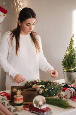 Anne ve kızı taze çam dalları ve şenlikli süslemeler kullanarak Noel çelengi yapıyorlar. Noel havası. Yüksek kalite fotoğraf