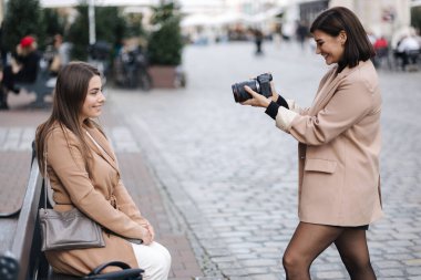 Güzel bir kadın bankta otururken fotoğrafçının fotoğraf çekmesini ilk gören kişi. Yüksek kalite fotoğraf