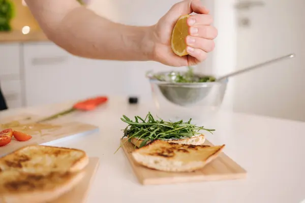 Human hand squeezes lemon on vegan sandwich. Vegan home made hood concept. High quality photo