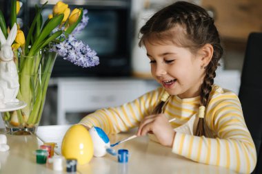 Küçük bir kızın mutfağa yumurta boyaması. Bahar tatili. Evde paskalya süsü. Yüksek kalite fotoğraf