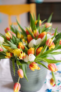 Masadaki vazoda farklı renkte çiçekler var. Renkli ve güzel taze laleler. Yüksek kalite fotoğraf