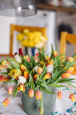 Masadaki vazoda farklı renkte çiçekler var. Renkli ve güzel taze laleler. Yüksek kalite fotoğraf