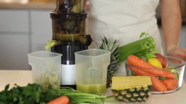 Taze meyve suyu için meyve ve sebzeli orta masa seçimi. Meyve sıkacağında ev yapımı içecek. Yüksek kalite 4k görüntü