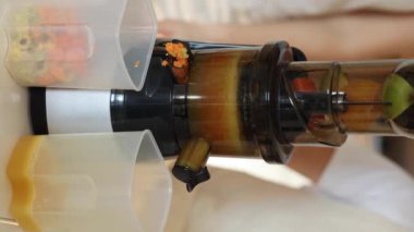 Bu işlem meyve sıkacağı gibi suyu sıkıyor. İnsan eli meyve sıkacağının kapağını açar ve meyve suyu kabın içine akar. Yüksek kalite 4k görüntü