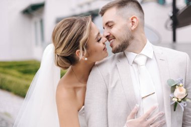 Yakışıklı genç damat güzel gelinini öpüyor. Parkta yürüyen düğün çifti. Yüksek kalite fotoğraf
