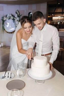 Güzel damat ve gelin restoranda düğün pastasını kestiler. Düğün günü biter. Yüksek kalite fotoğraf