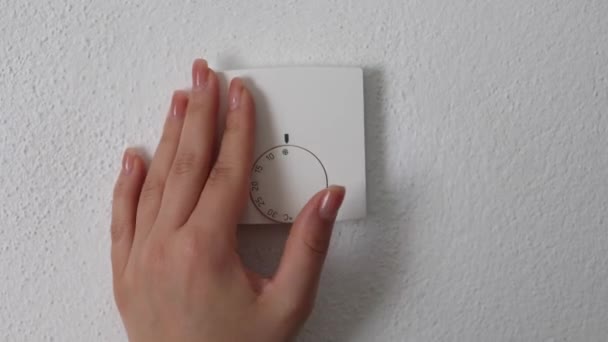 女性の手は中央の暖房サーモスタット 制御ダイヤルの調節を回します 摂氏20度で停止する お金と電気を節約する 高品質の4K映像 — ストック動画