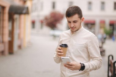 Şehirde bir fincan kahve ve telefon kullanan bir adam seçildi..