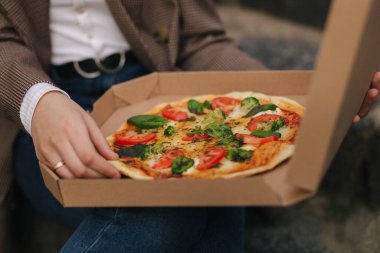 Kadın 'ın açık hava pizza kutusunu kapat. Kadın pizza kutusu açık ve iştah açıcı kokuyor..