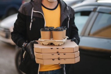 Adam arabadan sipariş alıyor. Teslimatçı çocuk pizza ve kahve getirdi. Teslimat servisi. Yüksek kalite fotoğraf