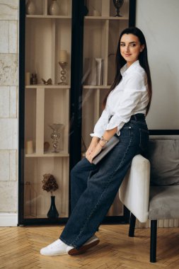 Çekici ve stil sahibi serbest yazar dizüstü bilgisayarla sandalyeye oturur. Kadın işi bitirir. Bilgi işlem müdürü. Yüksek kalite fotoğraf