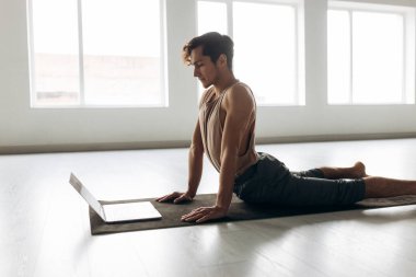 Bilgisayarda online eğitimle spor yapan yakışıklı bir genç. Yüksek kalite fotoğraf