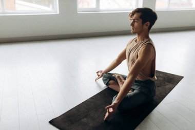 Yerde oturmuş meditasyon yapan yakışıklı, sakin bir adamın portresi. Yoga adam konsepti. Yüksek kalite fotoğraf