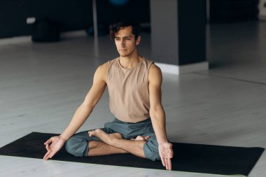 Yerde oturmuş meditasyon yapan yakışıklı, sakin bir adamın portresi. Yoga adam konsepti. Yüksek kalite fotoğraf