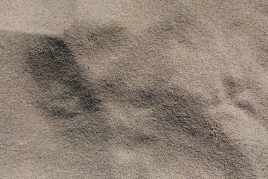 Metin kum arkaplanı. Arka plan olarak kumlu sahilin dokusu, üst manzara. Yüksek kalite fotoğraf