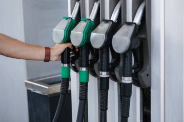 Benzin istasyonunda yakıt ikmali yapan genç bir adamın yakın çekimi. İnsan eliyle yapılan orta seçim yakıt pompası. Yüksek kalite fotoğraf