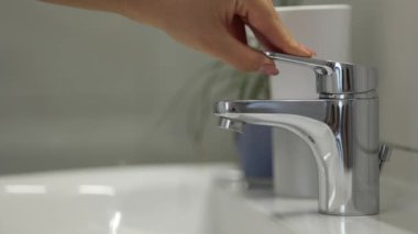 Kadın küvetteki suyu açmaya çalışıyor ama çok az su geliyor. Su kaynağıyla ilgili sorunlar. Yüksek kalite 4k görüntü