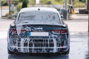 Beyaz köpüklü lüks araba oto yıkamada. Bekliyorum. Arkadan bak. Yüksek kalite fotoğraf