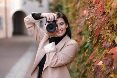 Kadın fotoğrafçının aynasız kamerasıyla fotoğraf çekmesi. Altın sonbahar. Mesaj için yer. Yüksek kalite fotoğraf