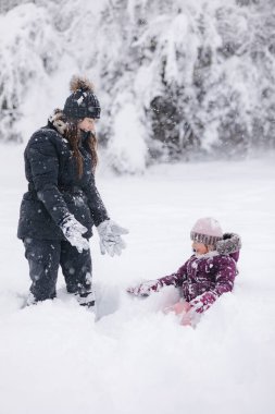 Karda oynayan bir anne ve kızın sevgi ve kış aile bağlarını yakalaması ne kadar da iç açıcı. Yüksek kalite fotoğraf