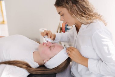 Profesyonel kadın kozmetolojist kozmetoloji kliniğinde işlem yapıyor. Yenilenme ve susuzluk. - Evet. Yüksek kalite fotoğraf