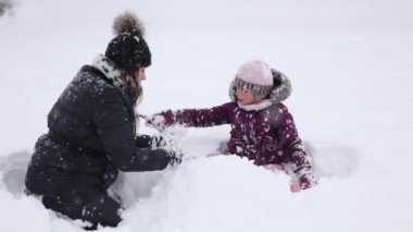 Karda oynayan bir anne ve kızın sevgi ve kış aile bağlarını yakalaması ne kadar da iç açıcı. Yüksek kalite 4k görüntü