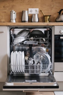 Bulaşık makinesi temiz tabak ve çatal bıçak dolu modern bir mutfak. Yüksek kalite fotoğraf