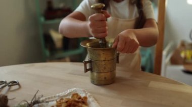 Bir çocuk otları öğütmek için havan ve tokmak kullanır, doğal malzemelerle aktif bir faaliyete girer. Keşif ve öğrenme temaları için mükemmel. Yüksek kalite 4k görüntü