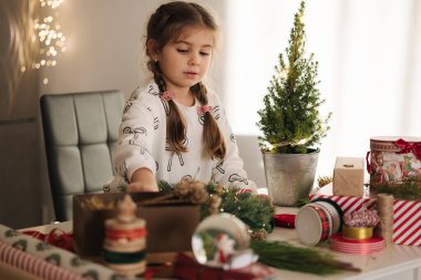 Sevimli beş yaşındaki kız evde Noel çelengi yapıyor. Kış tatiline hazırlanan sevimli küçük kız. Yüksek kalite fotoğraf