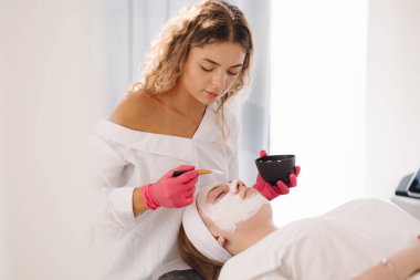 Cilt bakımı uzmanı kil maskeyi müşterilerin yüzüne iyice dağıtır, dengeli bir cilt için bile kapsama alanı sağlar. Yüksek kalite fotoğraf