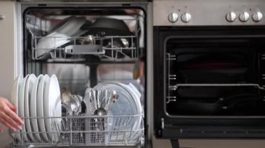 Kadın bulaşıklar temizlendikten sonra bulaşık makinesini kapattı. Yavaş çekim videosu. Yüksek kalite 4k görüntü